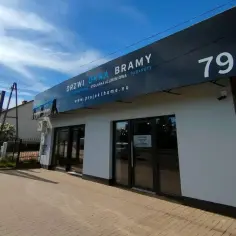 Nowoczesny salon okien i drzwi z dużym banerem reklamowym i numerem 79a.